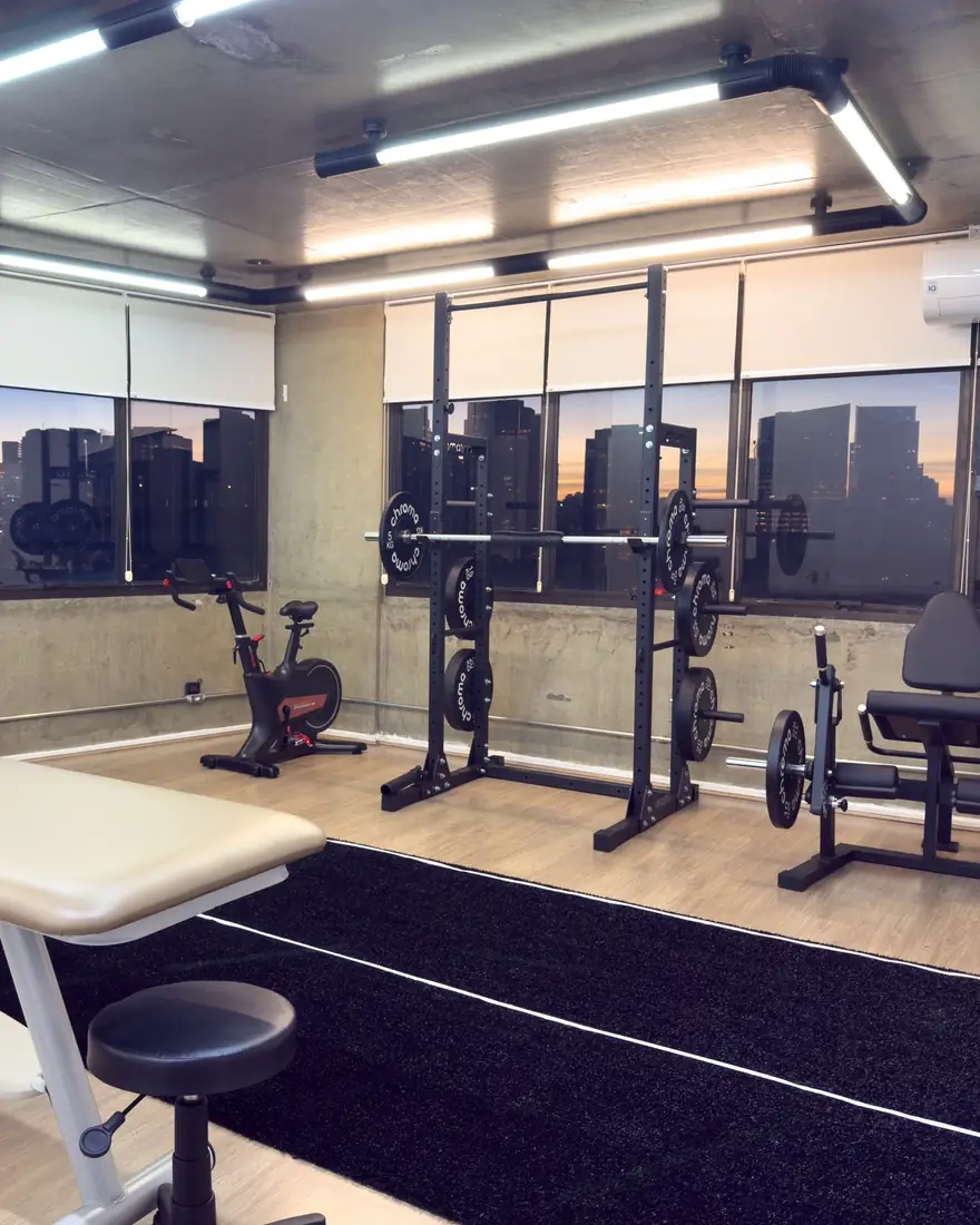 Sala de reabilitação da Joelho Mais Fisio, com rack de agachamento, bicicleta ergométrica e cadeira extensora